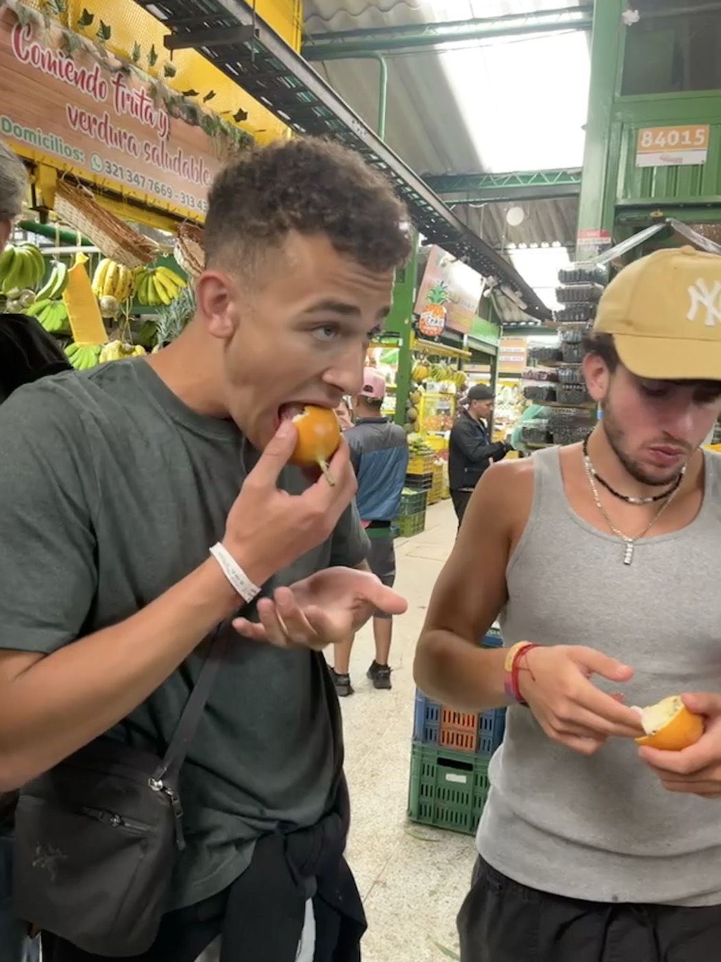 Nicky and Josh eating fresh fruit in a Colombian market